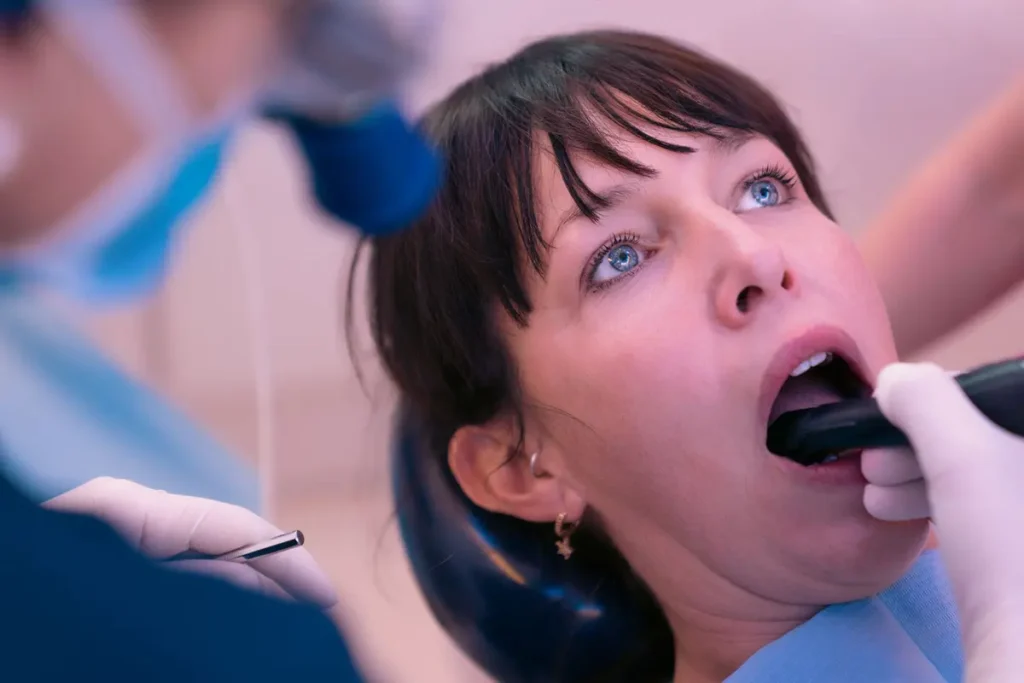 Esame dei denti con il manipolo Diagnocam a transilluminazione, senza radiazioni.